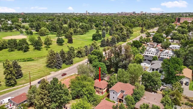 an aerial view of residential houses with outdoor space and trees