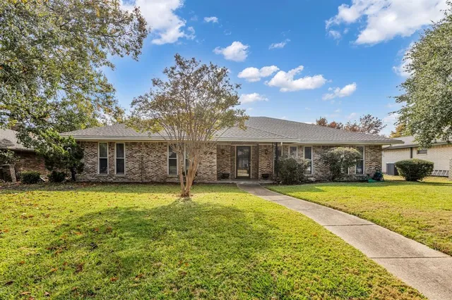 a view of a house with a yard and basket ball court and tables