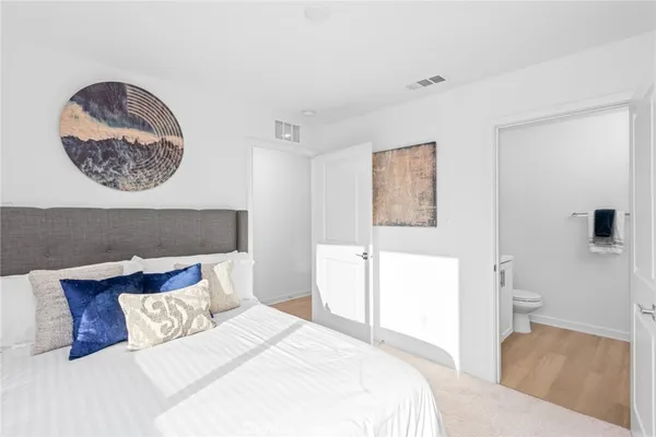a bedroom with a bed and a painting on the wall