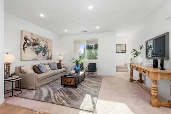 a living room with furniture flat screen tv and windows