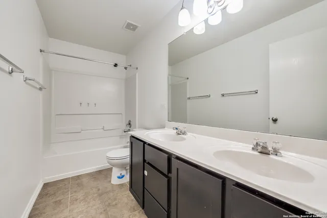 a bathroom with a sink a toilet a tub and shower