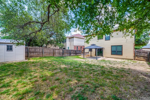 a front view of a house with a garden and trees