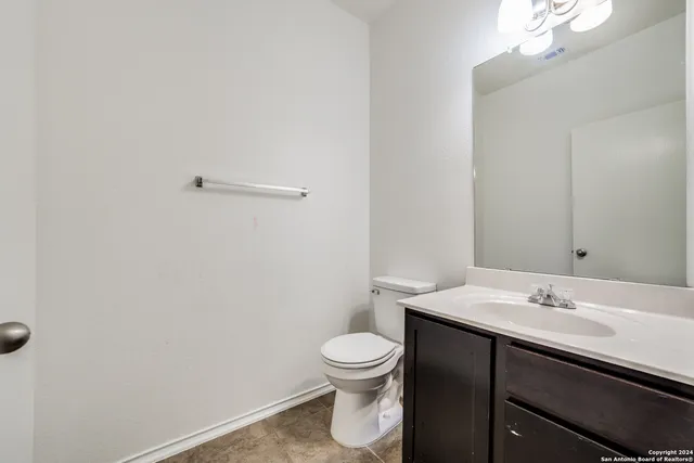 a bathroom with a sink a toilet and a mirror