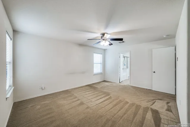 a view of an empty room with a chandelier fan