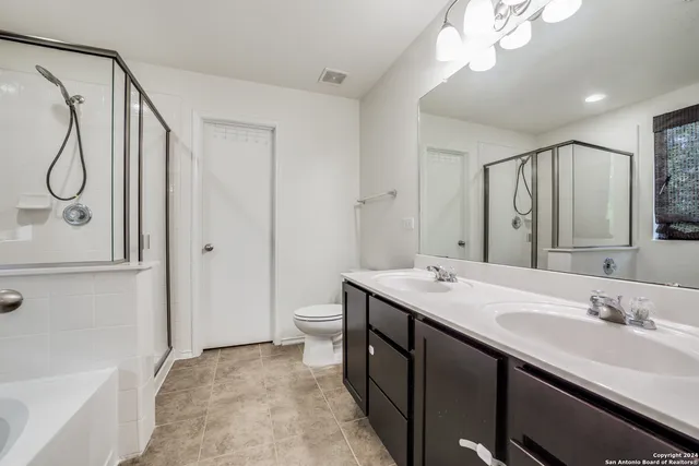 a bathroom with a double vanity sink mirror and toilet