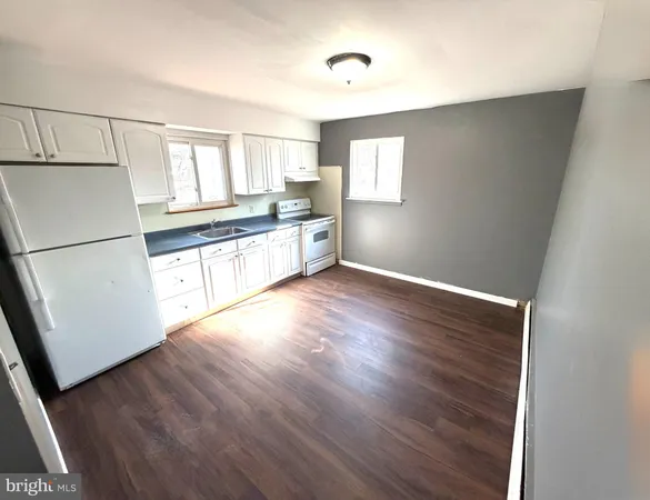 a kitchen with granite countertop white cabinets and white appliances