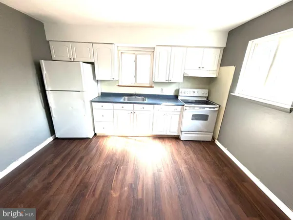 a kitchen with stainless steel appliances a refrigerator sink and wooden floor