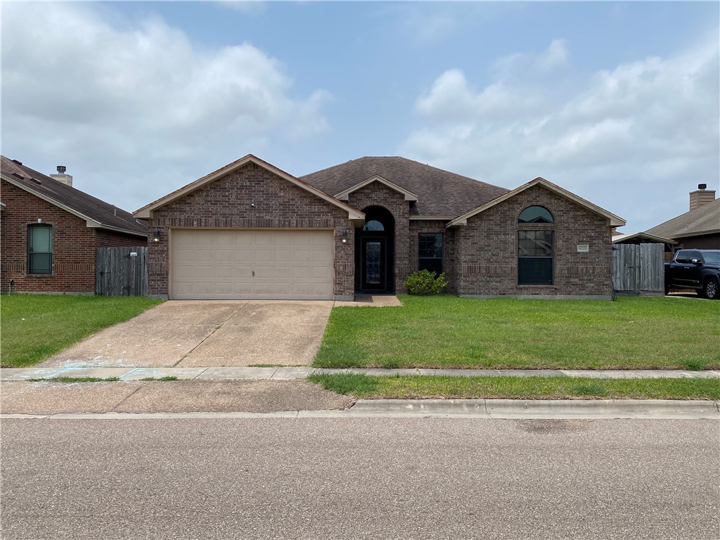 a front view of a house with a garden and garage
