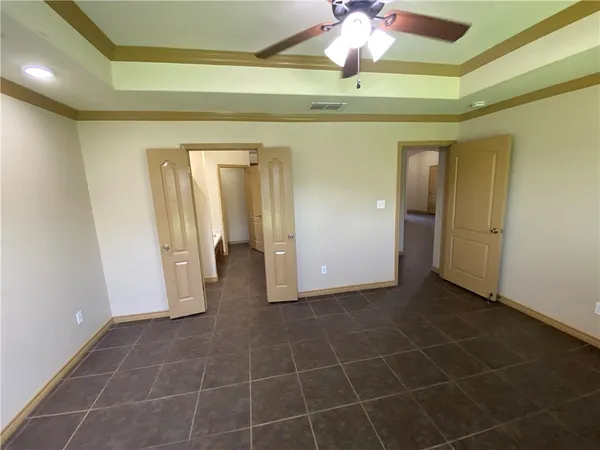 a view of a hallway to a room with a chandelier