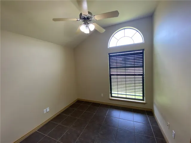 an empty room with windows and fan