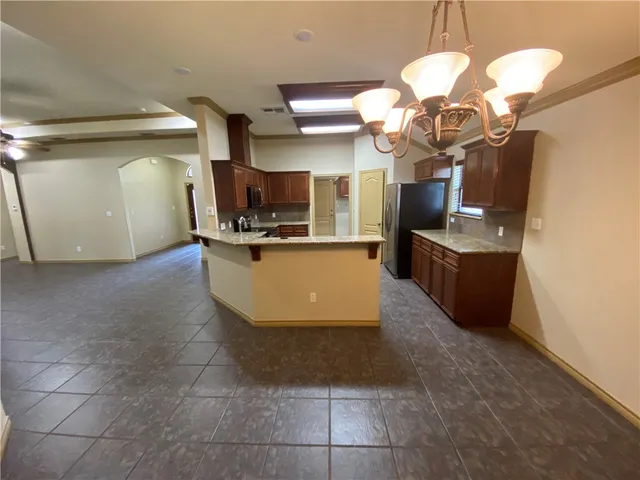 a kitchen with stainless steel appliances a sink a stove top oven a counter space and cabinets