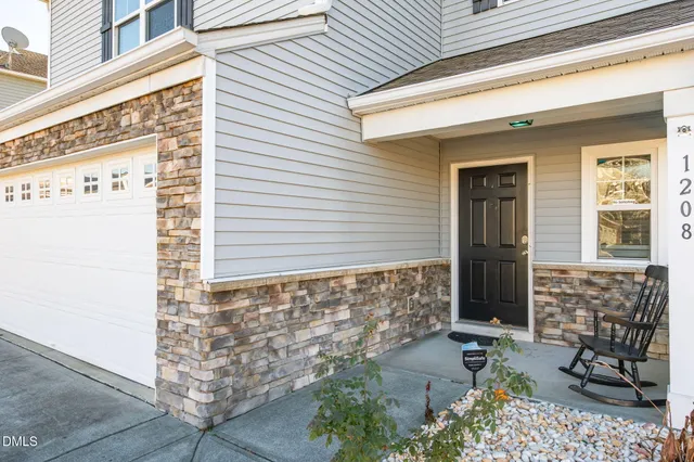 a front view of a house with a potted plant and garage