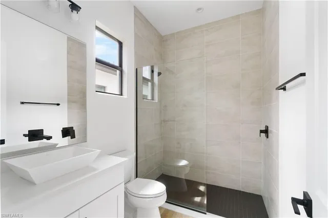 a bathroom with a sink a toilet a shower and a mirror