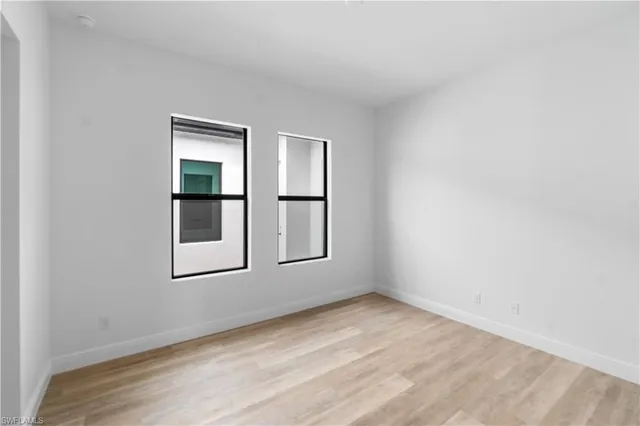an empty room with windows and closet