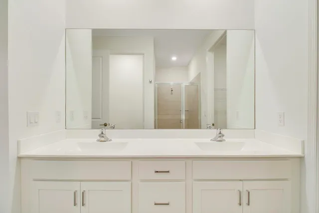 a bathroom with double sink and a mirror