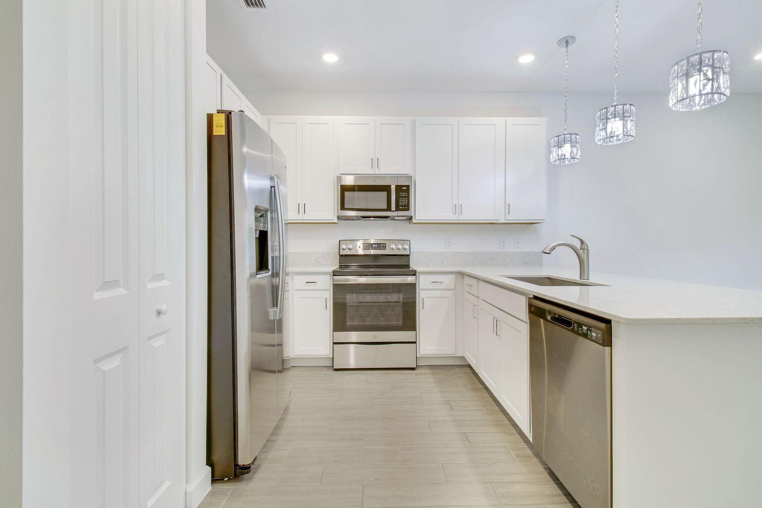 14556 Wiley Range Road Delray Beach, FL 33446 - Photo 5 of 29 a kitchen with granite countertop a refrigerator and a stove
