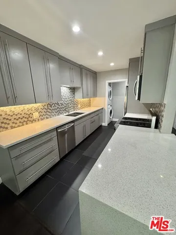 a kitchen with stainless steel appliances a stove a sink and a refrigerator