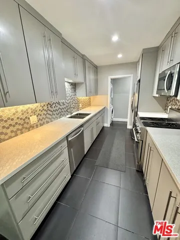 a kitchen with stainless steel appliances a sink stove and cabinets
