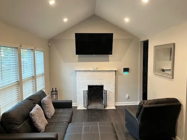 a living room with furniture a flat screen tv and a fireplace
