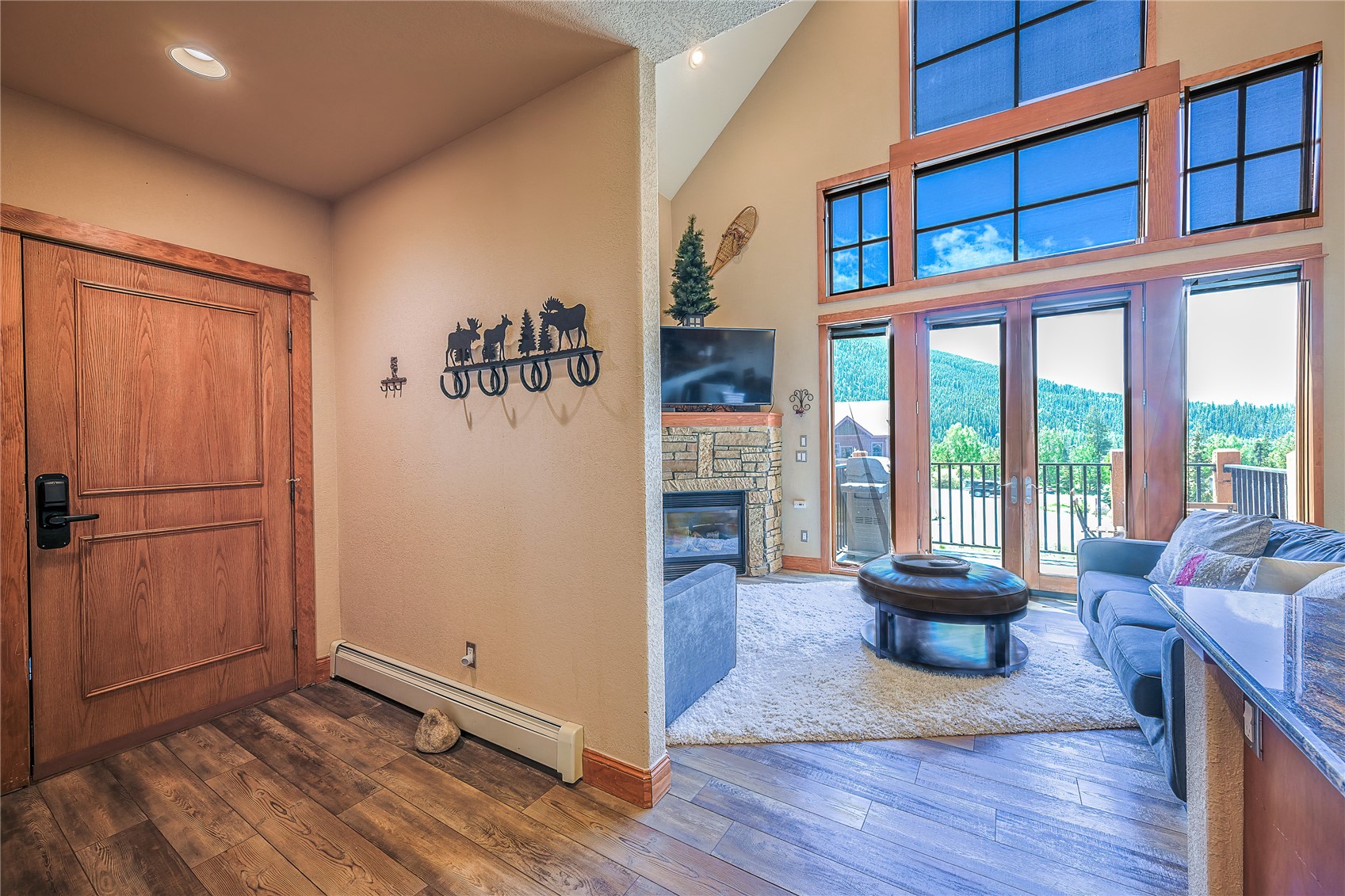 63 Antlers Gulch Road, Unit 104 Keystone, CO 80435 - Photo 7 of 23 Amazing views, stone fireplace, high vaulted ceiling, dark hardwood / wood-style flooring, and a baseboard radiator