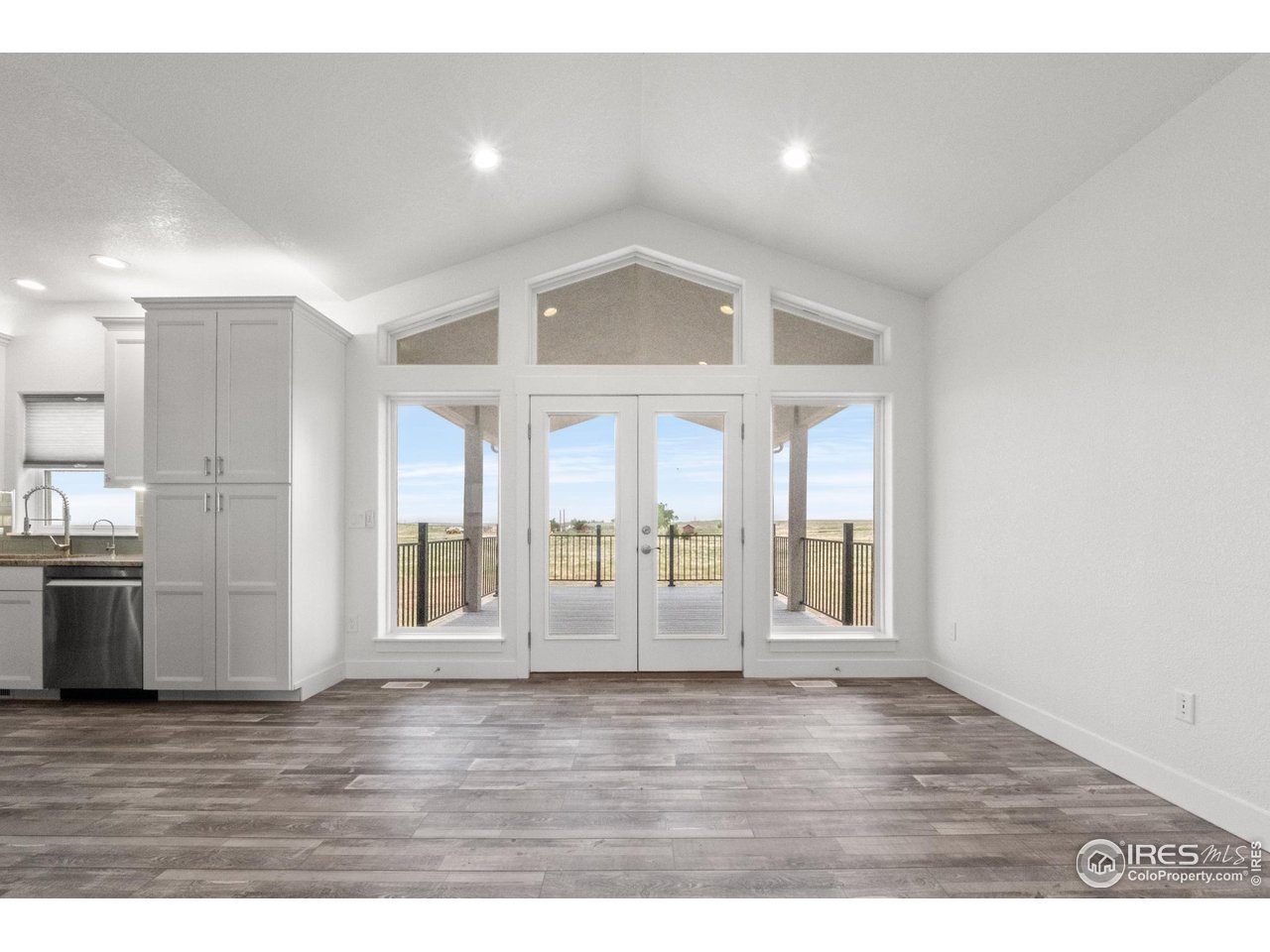 7908 P 3 Road Wiggins, CO 80654 - Photo 12 of 40 Vaulted ceilings lead to the outdoor back deck, creating a seamless indoor-outdoor flow.