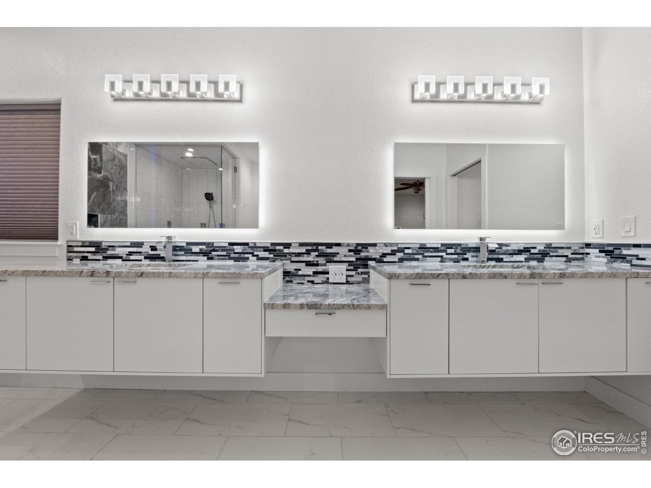 7908 P 3 Road Wiggins, CO 80654 - Photo 23 of 40 Elegant double floating vanities with backlit mirrors add modern luxury to the master bath.