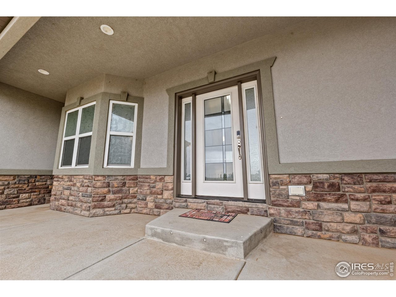 7908 P 3 Road Wiggins, CO 80654 - Photo 3 of 40 Inviting front entry with elegant stucco and stone finishes highlighting the home's modern design.