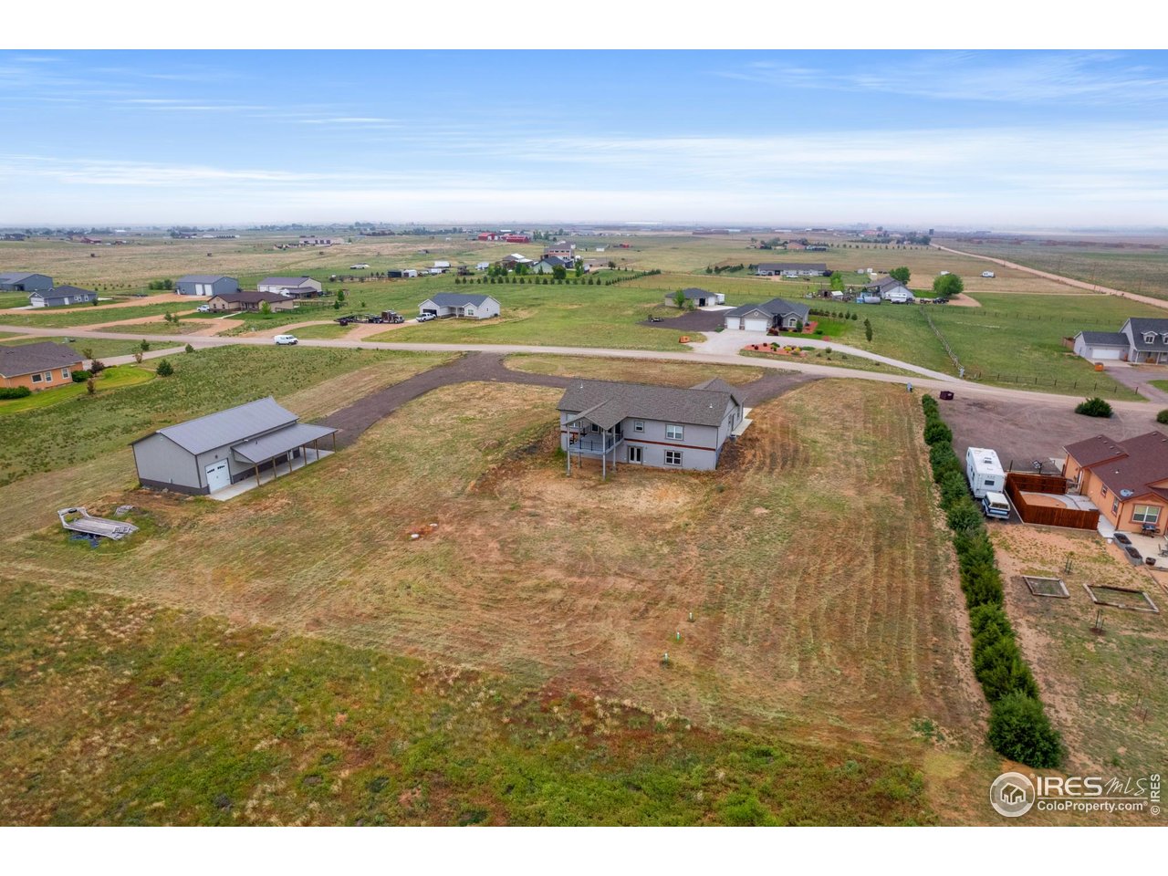 7908 P 3 Road Wiggins, CO 80654 - Photo 33 of 40 Aerial back view highlights the home's spacious layout, covered deck, and expansive backyard.