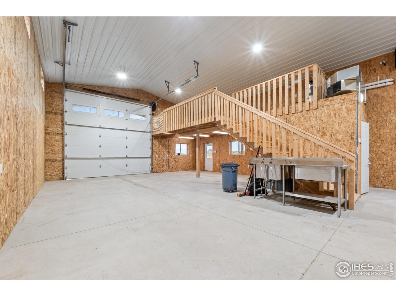 7908 P 3 Road Wiggins, CO 80654 - Photo 37 of 40 Interior view of the shop featuring the staircase to the 12'x28' loft and spacious layout.