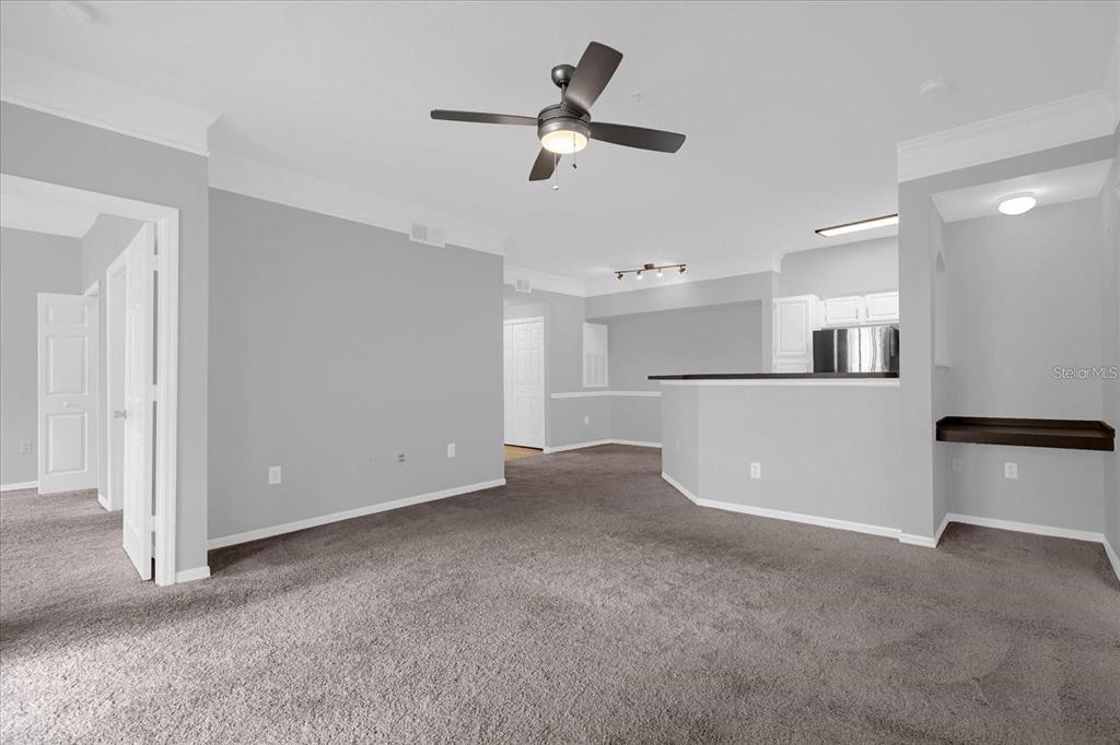 3250 Corona Village Way, Unit 102 Orlando, FL 32835 - Photo 12 of 33 a view of a kitchen with a refrigerator and a ceiling fan