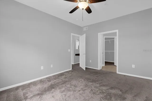 an empty room with chandelier fan