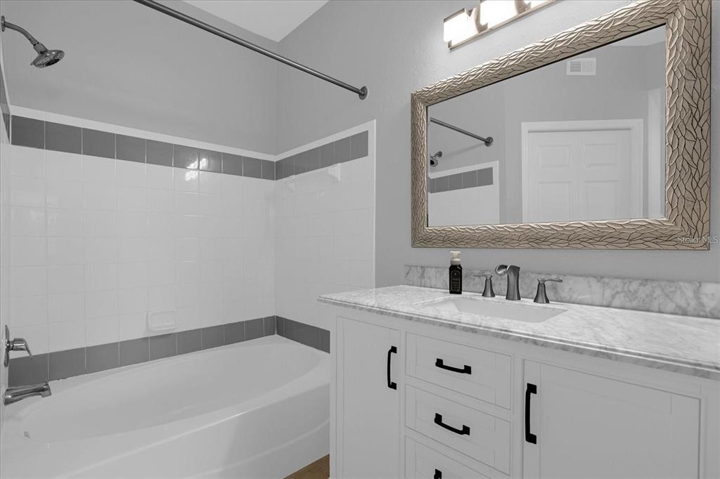 3250 Corona Village Way, Unit 102 Orlando, FL 32835 - Photo 18 of 33 a bathroom with a granite countertop sink and a mirror