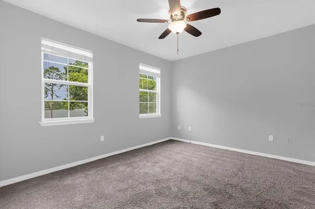 an empty room with a window and a fan