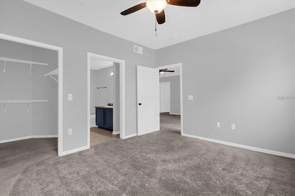 3250 Corona Village Way, Unit 102 Orlando, FL 32835 - Photo 21 of 33 an empty room with chandelier fan and kitchen view