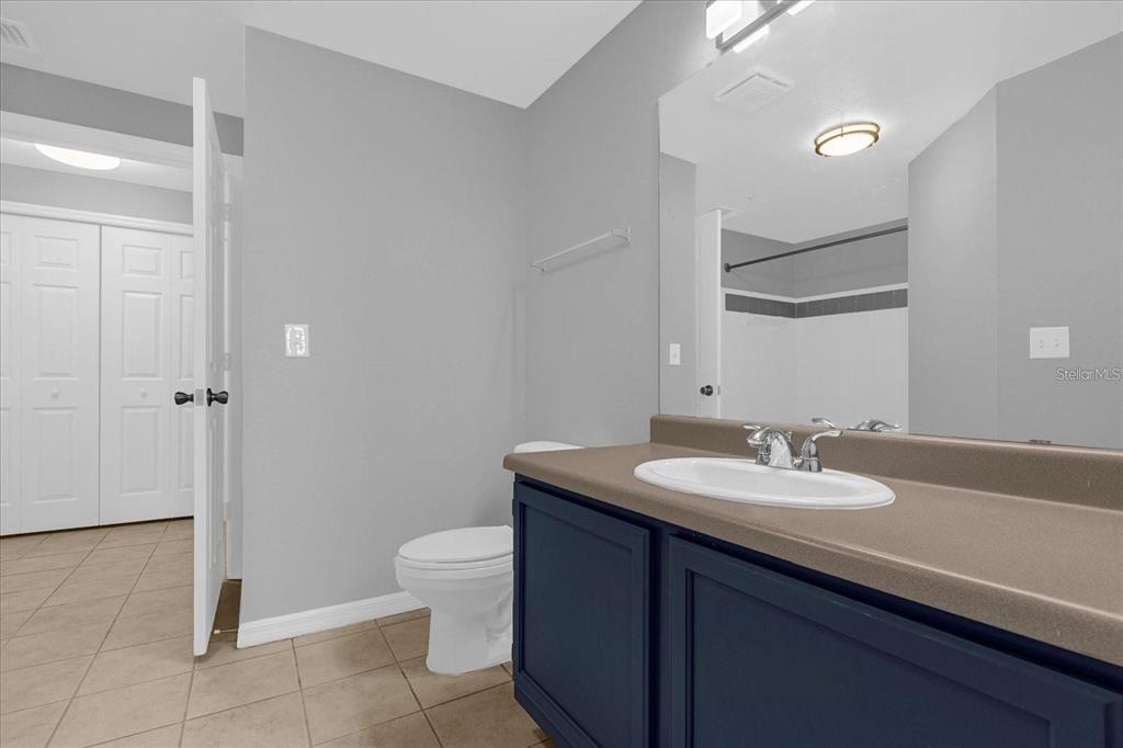 3250 Corona Village Way, Unit 102 Orlando, FL 32835 - Photo 22 of 33 a bathroom with a granite countertop sink a toilet and a mirror