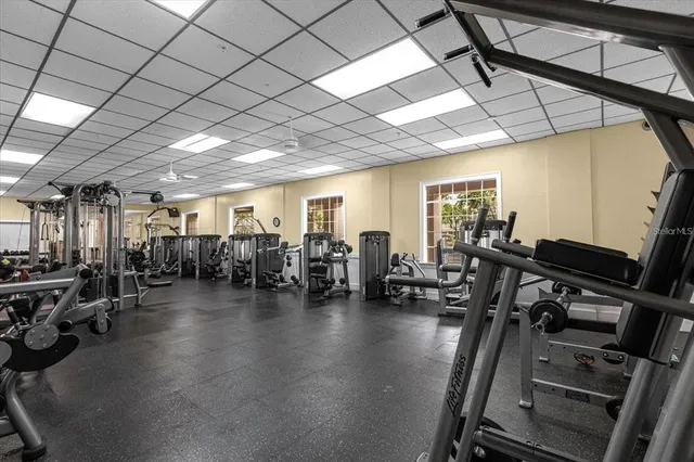 a gym room with lots of gym equipment and a large window