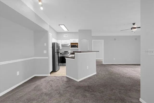 a view of a kitchen with refrigerator and white cabinets