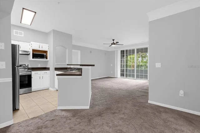 a kitchen with granite countertop white cabinets and stainless steel appliances