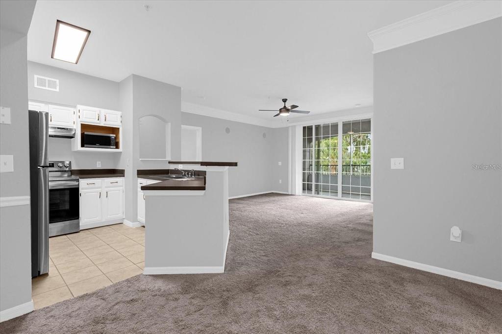 3250 Corona Village Way, Unit 102 Orlando, FL 32835 - Photo 7 of 33 a kitchen with granite countertop white cabinets and stainless steel appliances
