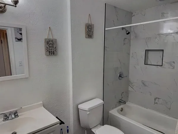 a bath room with a toilet sink and a bath tub