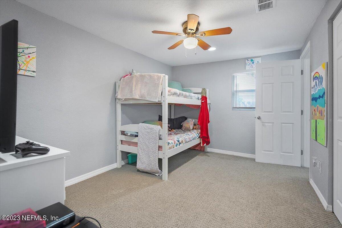 197 Lynn Street St. Augustine, FL 32084 - Photo 15 of 24 a bedroom with a bed and a chandelier