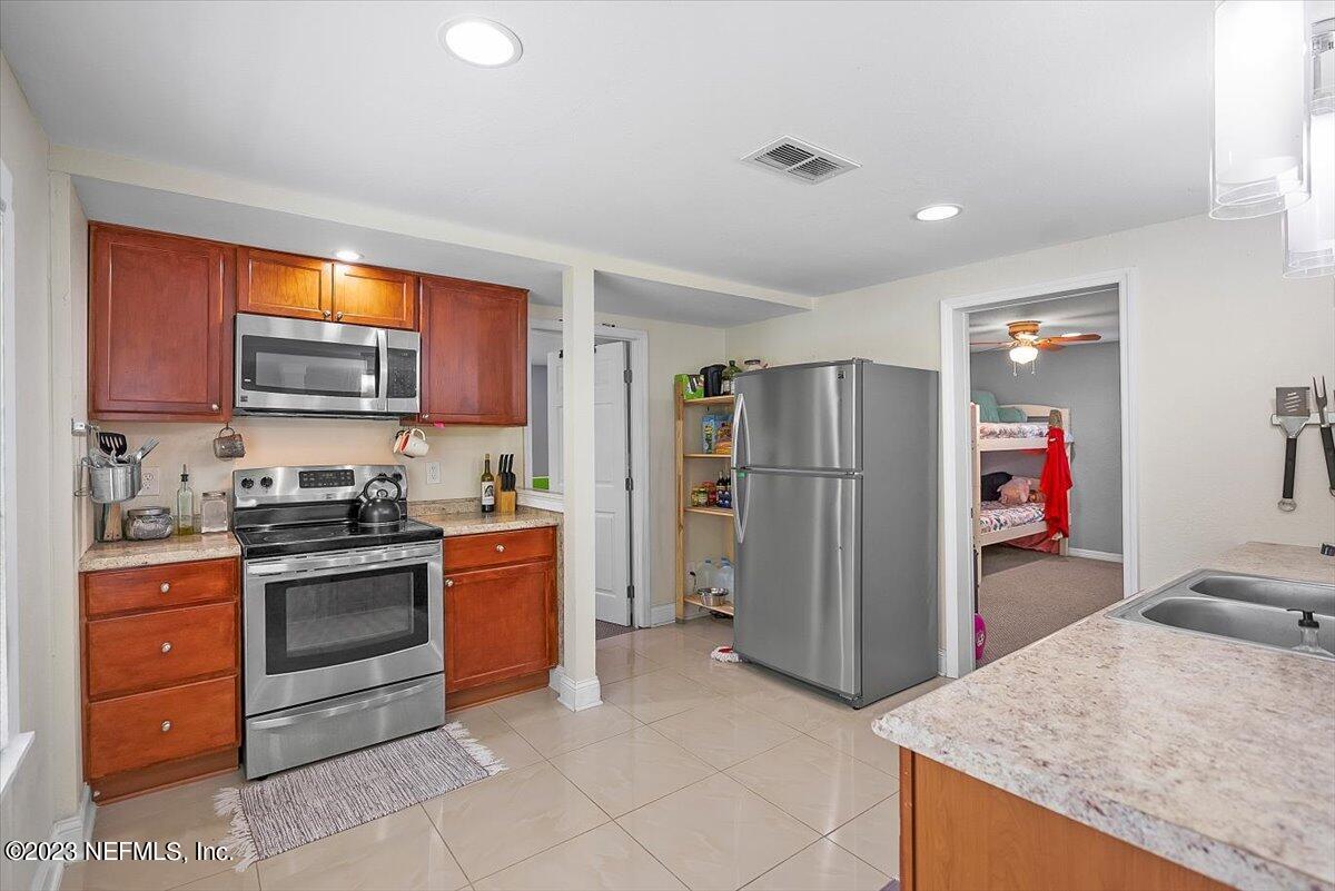 197 Lynn Street St. Augustine, FL 32084 - Photo 9 of 24 a kitchen with stainless steel appliances granite countertop a refrigerator and a stove top oven