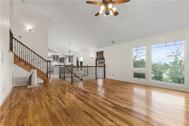 a view of an empty room with wooden floor and a large window