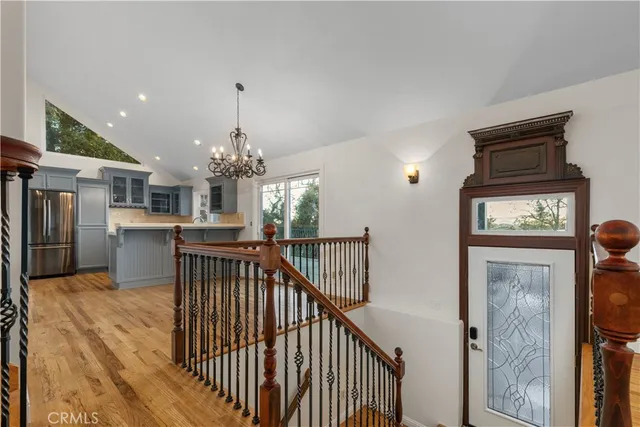 a view of a hallway with wooden floor and a kitchen
