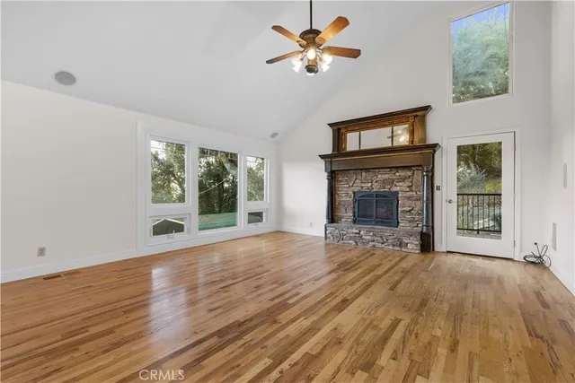 a view of an empty room with a fireplace and a window
