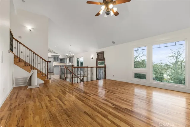 a view of an empty room with wooden floor and a large window