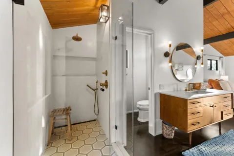a bathroom with a granite countertop sink mirror toilet and shower