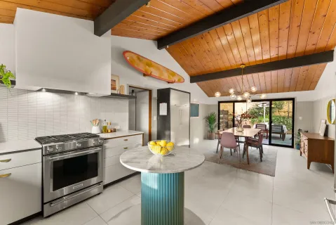 a kitchen with a stove a sink and chairs