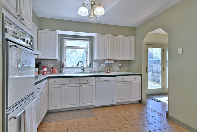 a kitchen with a sink window and cabinets