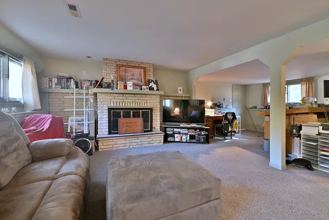 a living room with furniture a fireplace and a flat screen tv